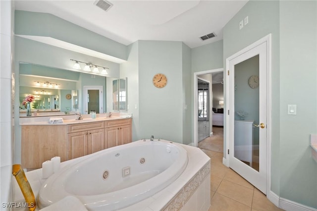 bathroom with tile patterned floors, visible vents, vanity, and a tub with jets