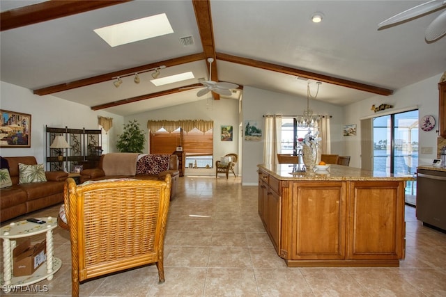 kitchen featuring lofted ceiling with skylight, brown cabinets, a wealth of natural light, and ceiling fan with notable chandelier