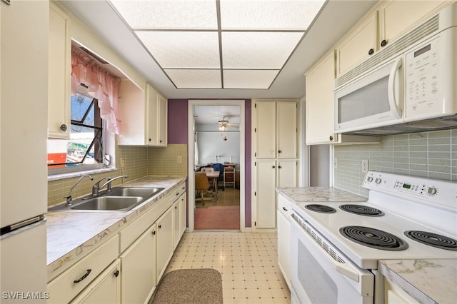 kitchen with light floors, white appliances, a sink, and light countertops