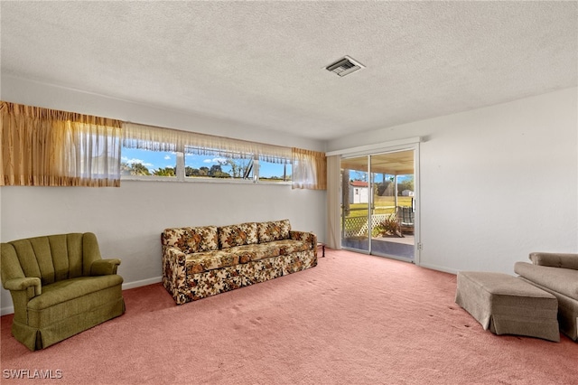 sitting room with carpet floors, baseboards, visible vents, and a textured ceiling