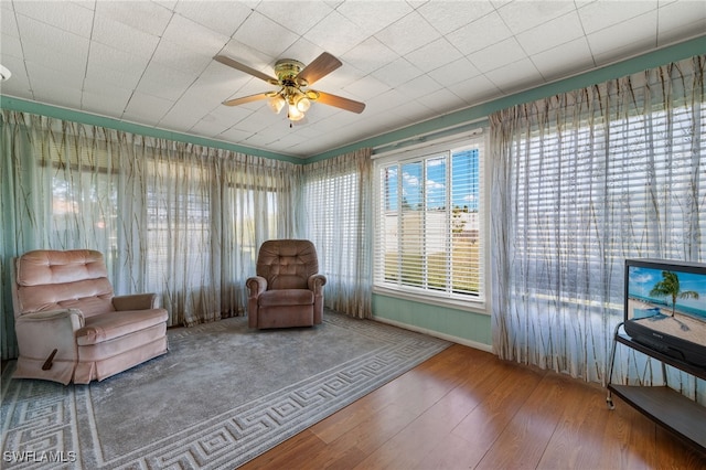 sitting room with wood finished floors and a ceiling fan