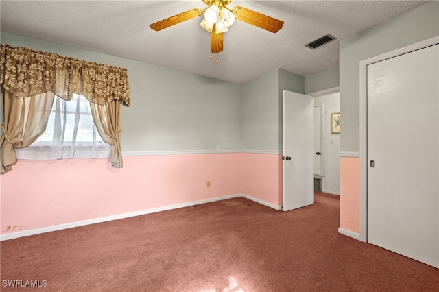 unfurnished bedroom with baseboards, carpet, visible vents, and a textured ceiling