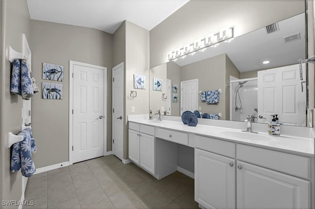 bathroom with tile patterned floors, a sink, visible vents, and a shower stall