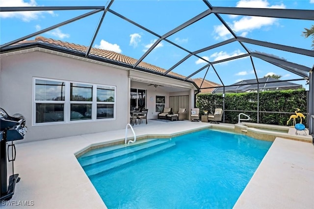 view of pool featuring ceiling fan, glass enclosure, outdoor lounge area, a pool with connected hot tub, and a patio area