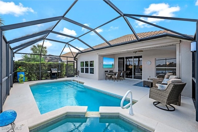 view of pool with a ceiling fan, a lanai, a grill, a patio area, and a pool with connected hot tub