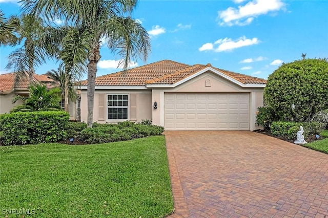 view of front of property with a garage, a tile roof, decorative driveway, a front lawn, and stucco siding