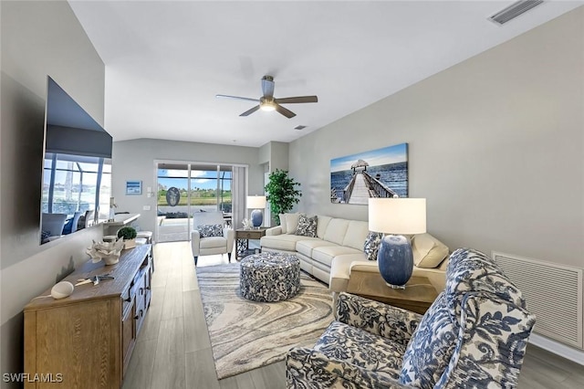 living room with ceiling fan, visible vents, and wood finished floors