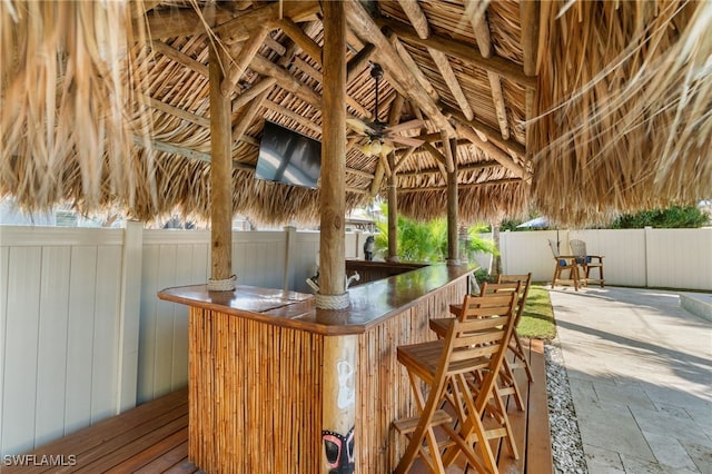 view of patio featuring fence, outdoor dry bar, a gazebo, and ceiling fan