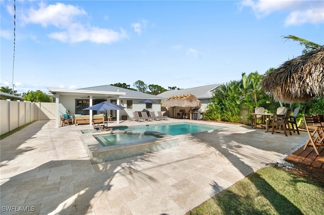 view of pool with a patio, a fenced backyard, and a pool with connected hot tub