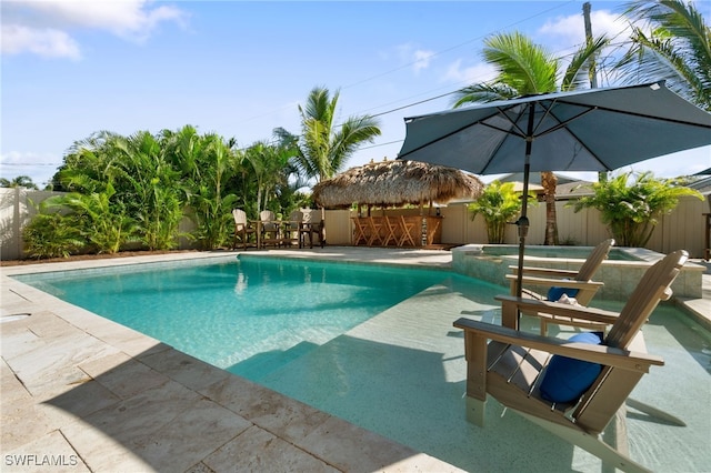 view of swimming pool with a patio area, a fenced backyard, and a pool with connected hot tub