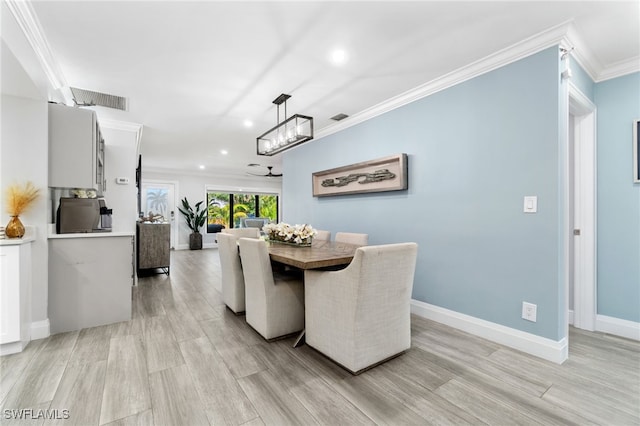 dining space with ornamental molding, light wood-type flooring, visible vents, and baseboards