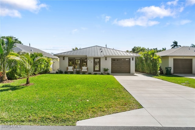 view of front of property with a front yard, a standing seam roof, metal roof, a garage, and driveway