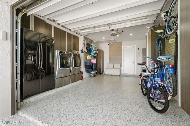 garage featuring independent washer and dryer and a garage door opener