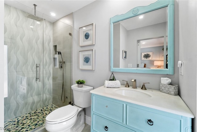 bathroom featuring a shower stall, toilet, and vanity