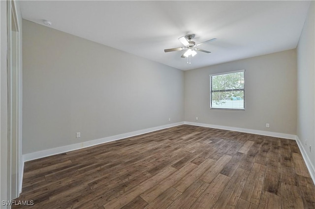 empty room with dark wood-style floors, ceiling fan, and baseboards