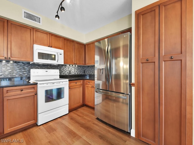 kitchen with white appliances, visible vents, decorative backsplash, dark countertops, and light wood-type flooring