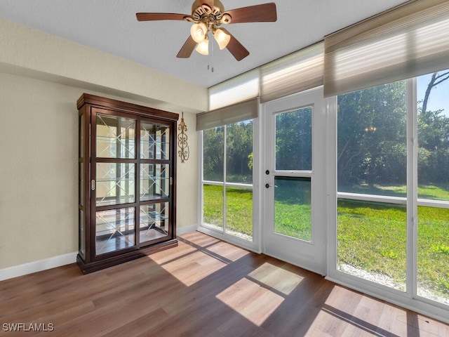 unfurnished sunroom featuring a ceiling fan