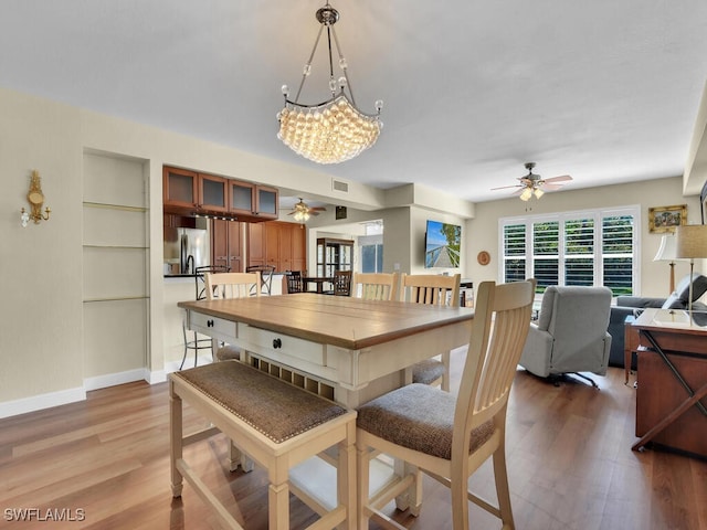 dining space with light wood-style floors, ceiling fan, and visible vents