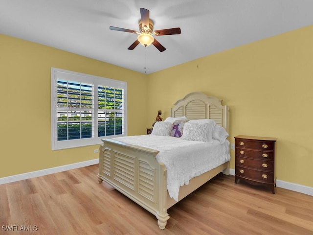 bedroom featuring light wood-style floors, ceiling fan, and baseboards