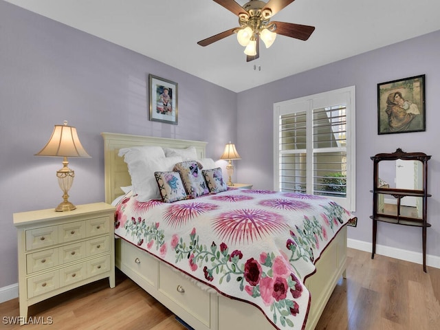 bedroom featuring light wood finished floors, a ceiling fan, and baseboards