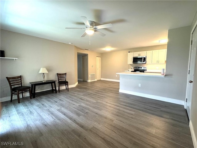 interior space with dark wood finished floors, visible vents, and baseboards