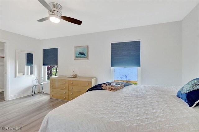 bedroom featuring a ceiling fan, light wood-style flooring, and baseboards