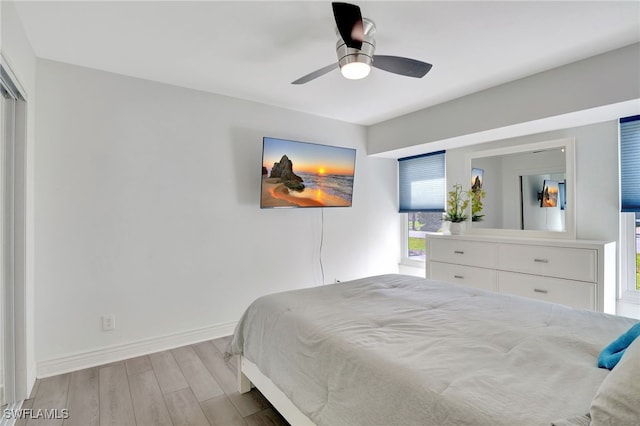 bedroom featuring a ceiling fan, baseboards, and wood finished floors