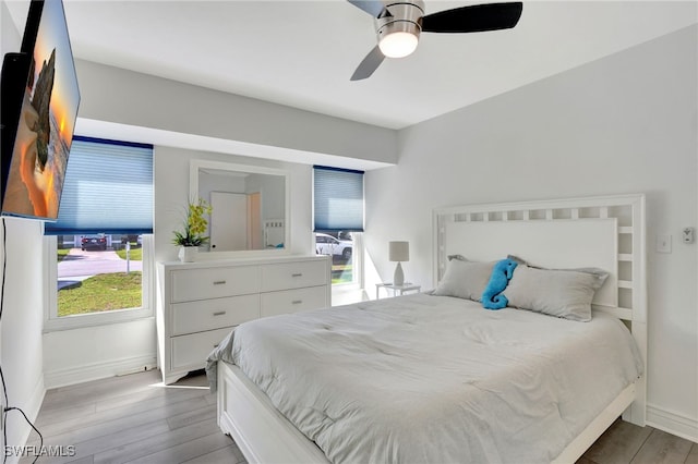 bedroom featuring ceiling fan, baseboards, and wood finished floors