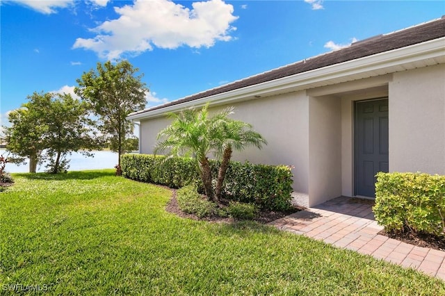 view of property exterior featuring stucco siding and a yard