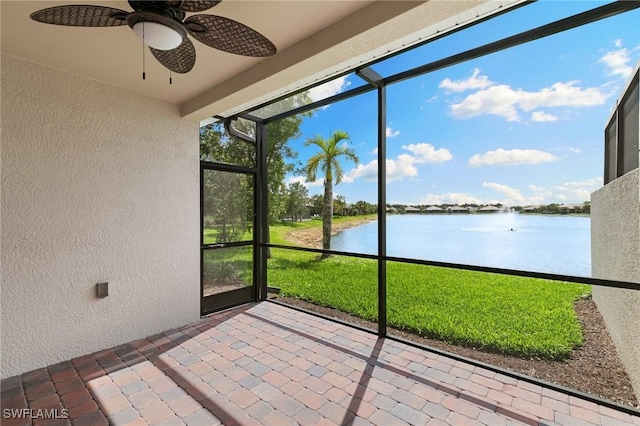 unfurnished sunroom with a water view and ceiling fan