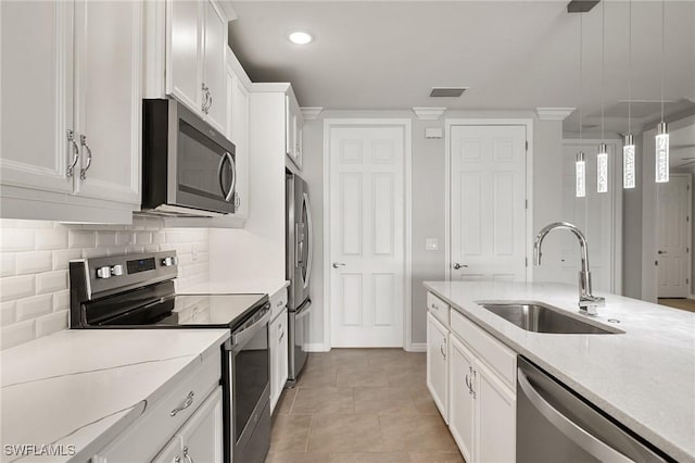 kitchen featuring visible vents, decorative backsplash, appliances with stainless steel finishes, white cabinetry, and a sink