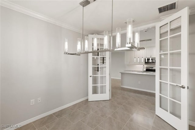 unfurnished dining area featuring baseboards, visible vents, ornamental molding, french doors, and a sink