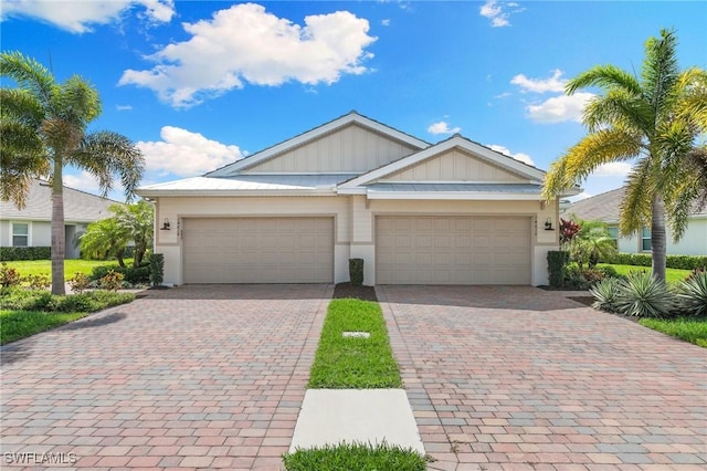 view of front of house with a garage, board and batten siding, and decorative driveway