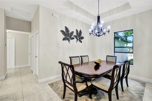 dining room with a healthy amount of sunlight, light tile patterned floors, baseboards, and a raised ceiling