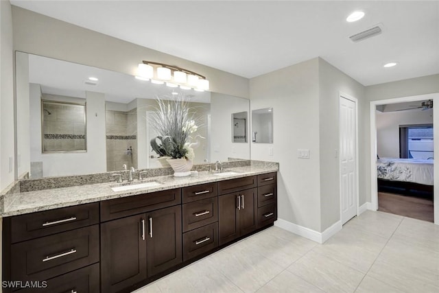 full bathroom featuring double vanity, visible vents, a walk in shower, and a sink