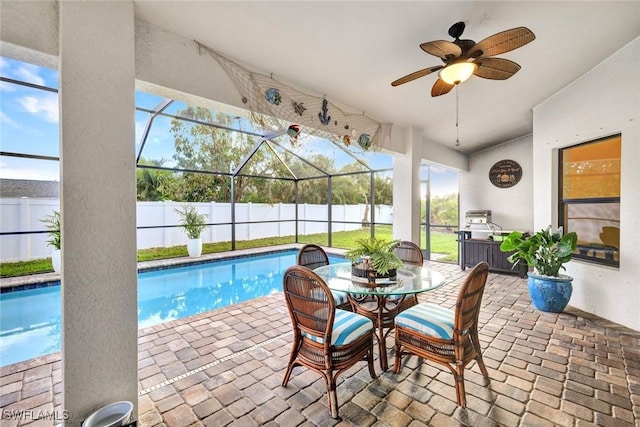 view of pool featuring ceiling fan, a patio, fence, and glass enclosure