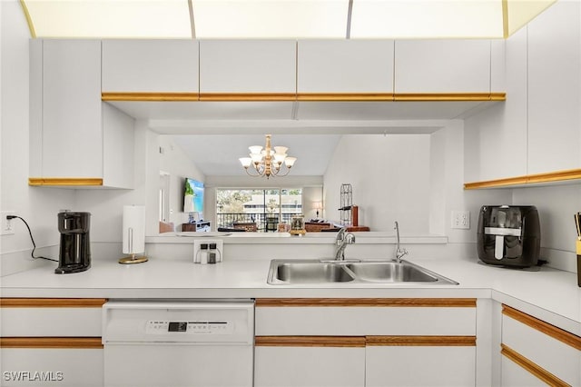 kitchen with dishwasher, light countertops, a sink, and white cabinets