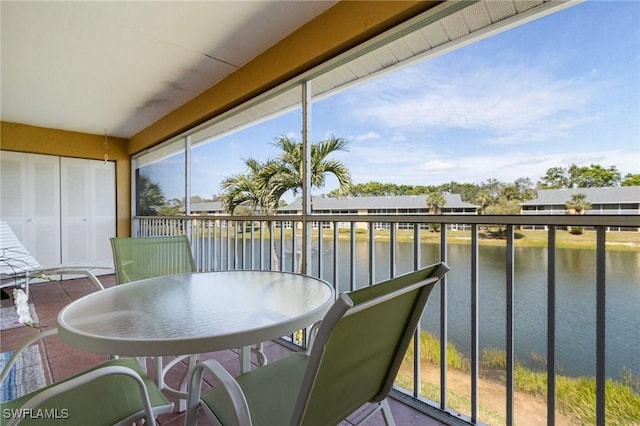 sunroom featuring a water view