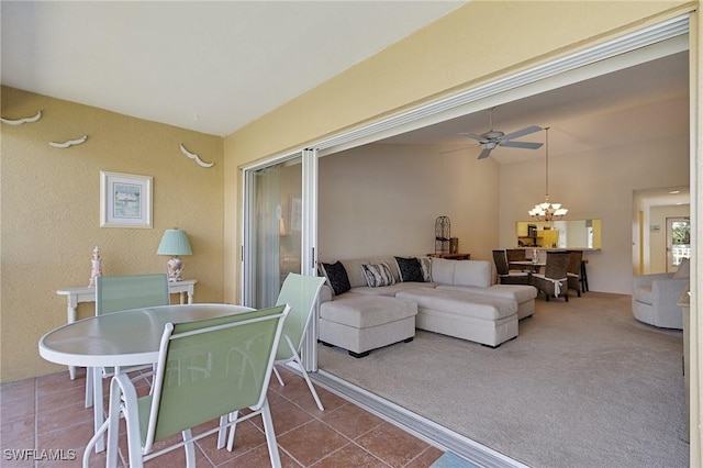 carpeted living room with tile patterned flooring and ceiling fan with notable chandelier