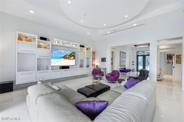 living area featuring recessed lighting, french doors, and a raised ceiling