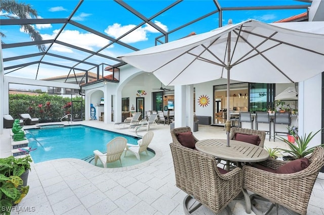 pool featuring glass enclosure and a patio