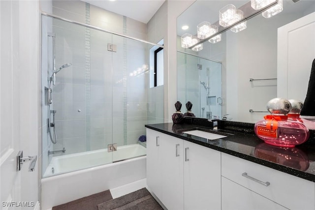 bathroom featuring combined bath / shower with glass door, an inviting chandelier, and vanity