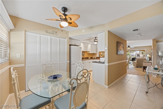 dining area featuring light tile patterned floors, a ceiling fan, visible vents, and baseboards