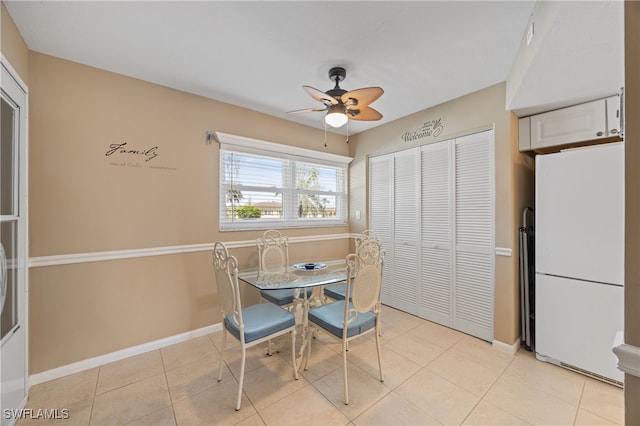 dining room featuring ceiling fan, baseboards, and light tile patterned floors