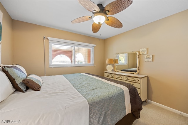 bedroom with baseboards, a ceiling fan, and light colored carpet