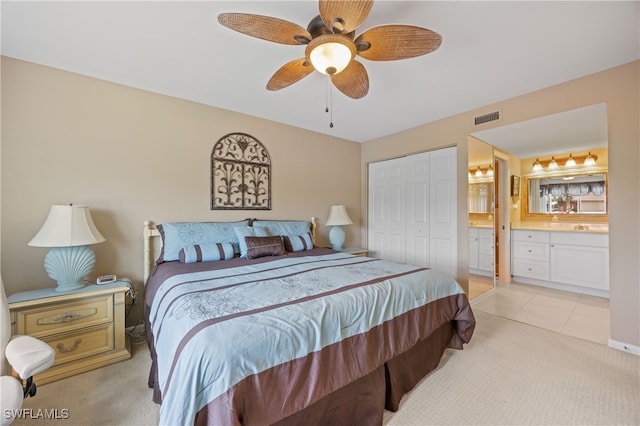 bedroom featuring ensuite bathroom, light carpet, a ceiling fan, visible vents, and a closet