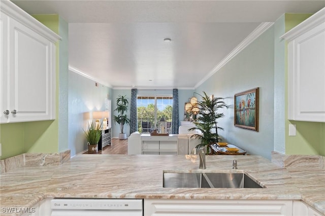 kitchen featuring white dishwasher, white cabinetry, light stone counters, and crown molding