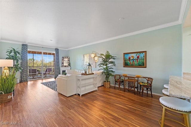 living area with crown molding, baseboards, and wood finished floors