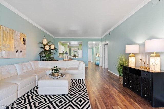 living room featuring ornamental molding, wood finished floors, visible vents, and baseboards