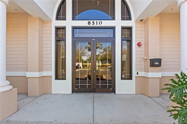 property entrance featuring stucco siding and french doors